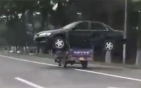 Китаец умудрился перевезти автомобиль на мотоцикле (видео)