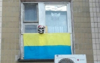 Киевлянин украсил окно квартиры перевернутым флагом и черепом