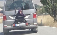 Отец прокатил 13-летнюю дочь, привязав к багажнику (видео)