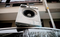 Мужчина в порыве злости сбросил стиральную машину на автомобиль