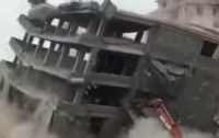 В Китае при сносе здания на экскаватор упал дом (видео)