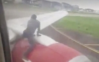Мужчина забрался на крыло самолета при взлете (видео)